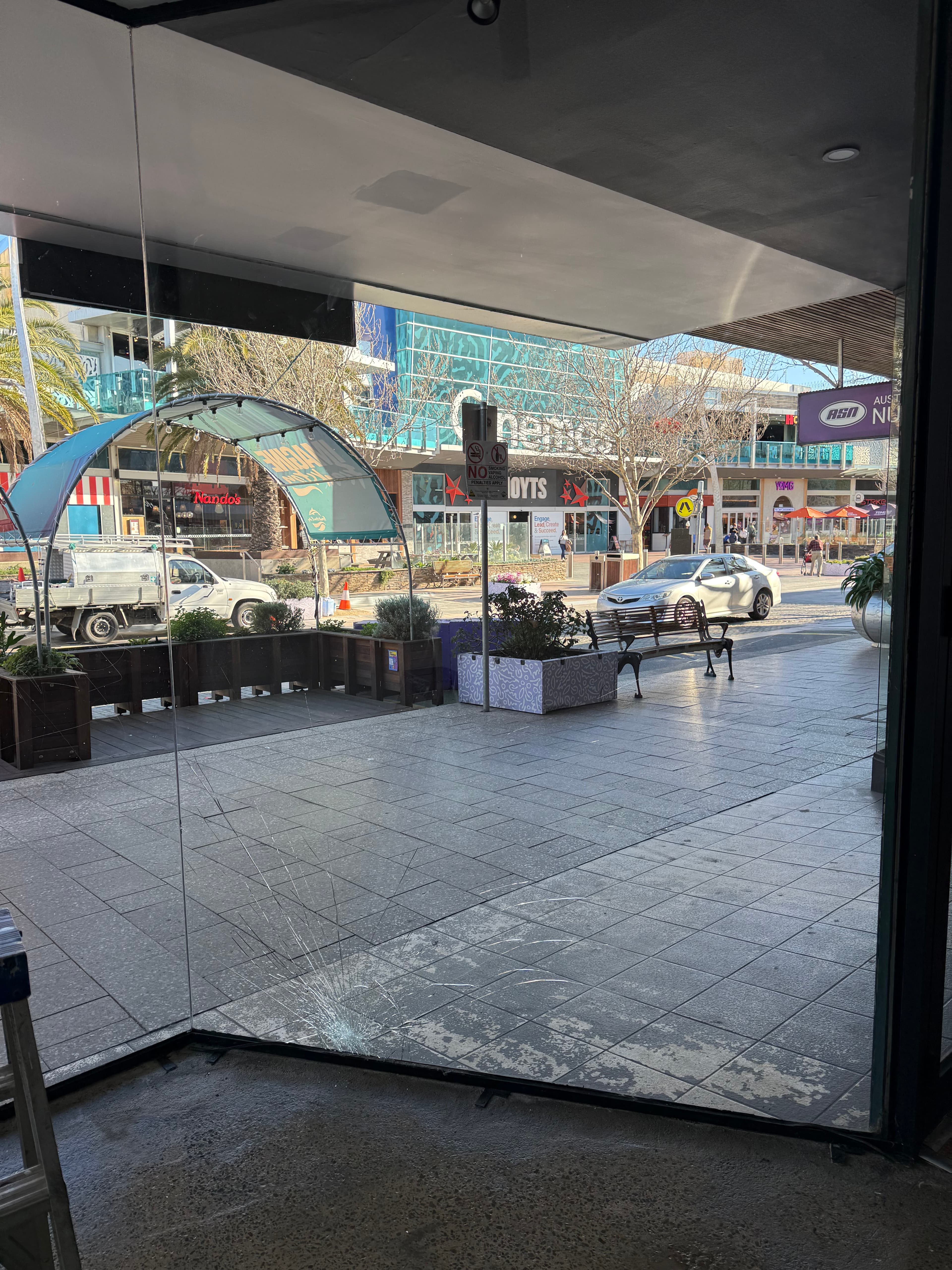 Smashed shopfront glass with cracks on a Frankston retail strip